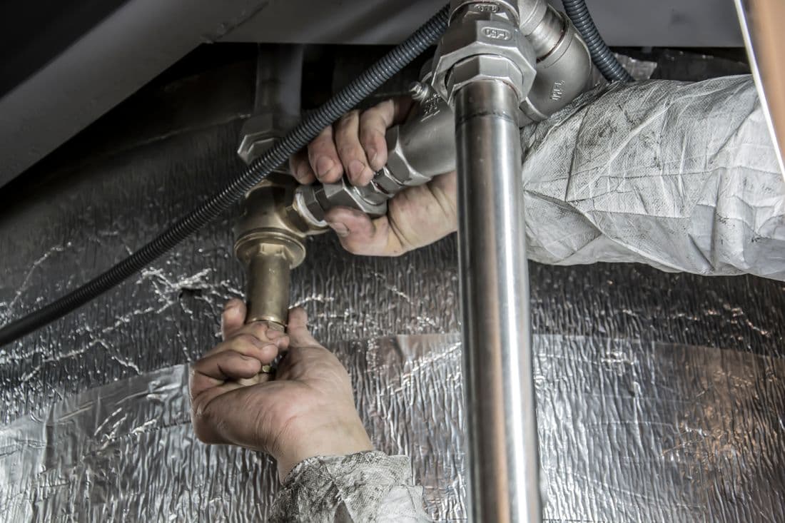Plumber installing steel pipe fittings on a real job site