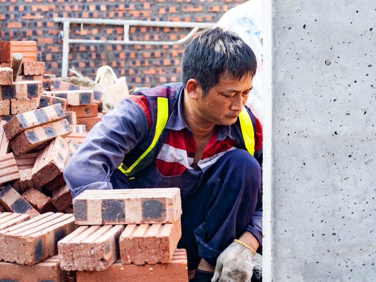 Mason laying bricks at a construction site