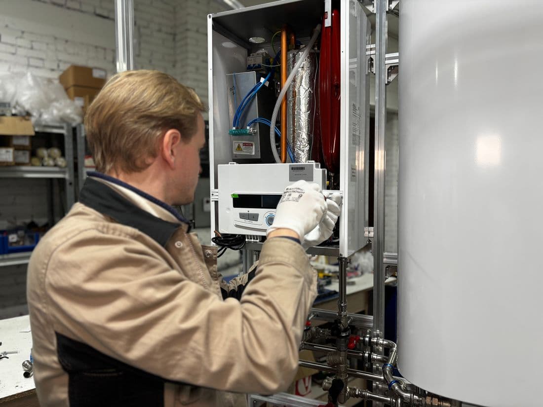 Technician installing or repairing a heating system in a workshop