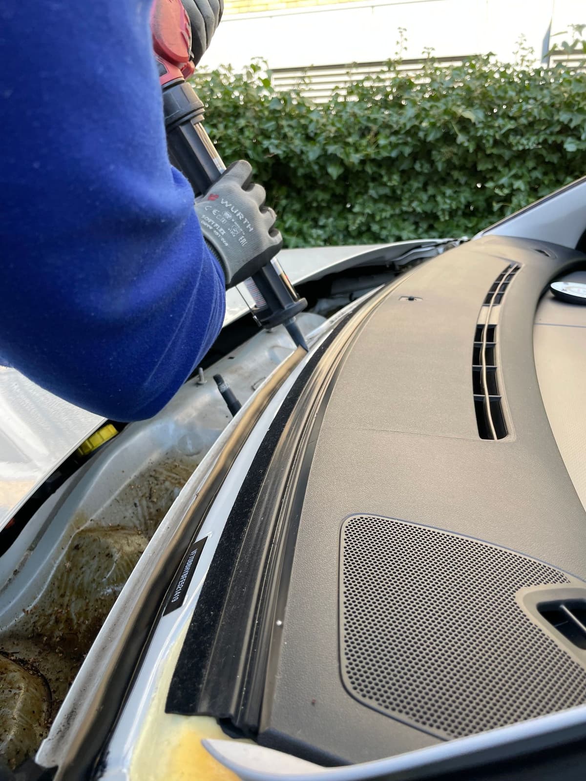 Professional auto glass tech performing auto glass repair on a real job